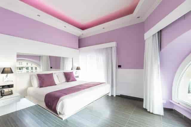 Luxury executive hotel room with purple decor for VIP corporate stays and boutique events.