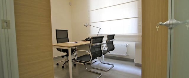 Minimalist breakout room at Alma Business Center for private meetings and consultations.