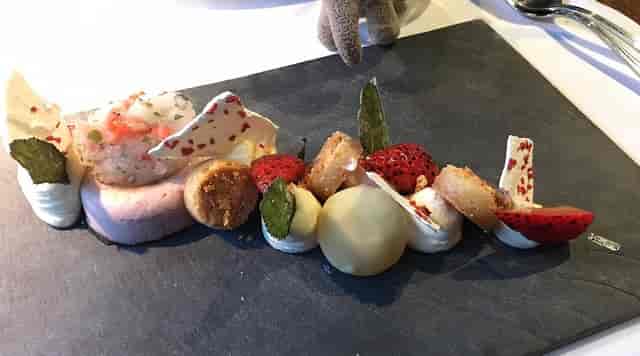Artfully plated dessert on slate board for high-end gala catering event.