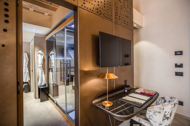 Martius Private Suites premium hotel room with glass bathroom for corporate travel and events.