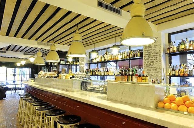 Industrial restaurant venue with marble bar for corporate events and networking mixers.
