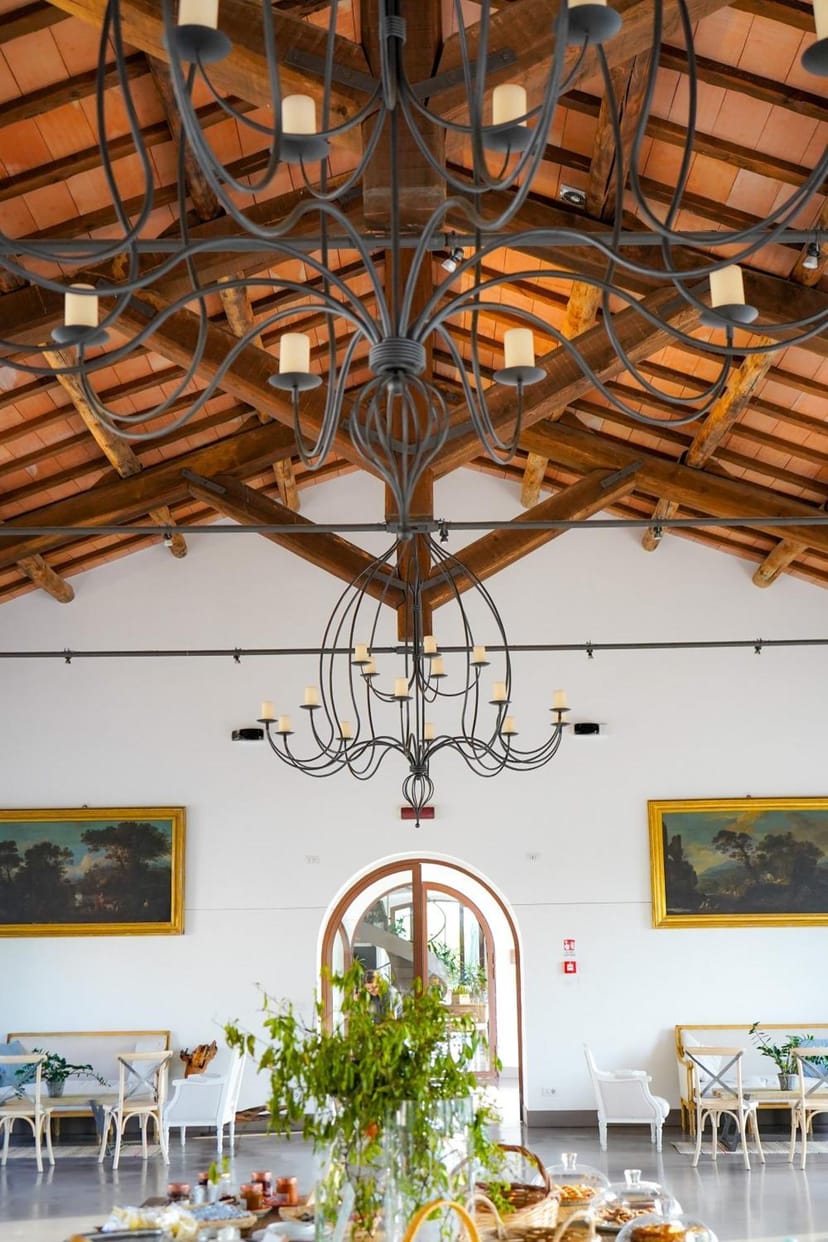 Rustic Borgo Pallavicini Mori dining hall with wooden beams for wedding or corporate gala.