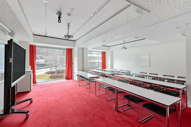 Classroom-style meeting room at Best Western Stockholm, featuring bold red accents for workshops.