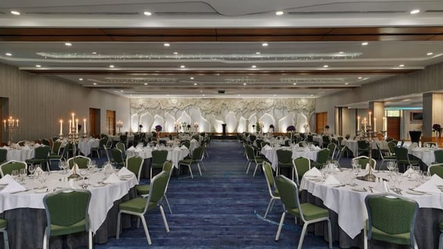 Ballroom gala setup with illuminated stage, perfect for elegant banquet and wedding events.