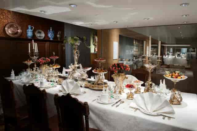 Luxury dining table setup with ornate silver centerpieces for corporate VIP event hospitality.