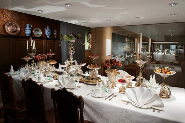 Luxury dining table setup with ornate silver centerpieces for corporate VIP event hospitality.