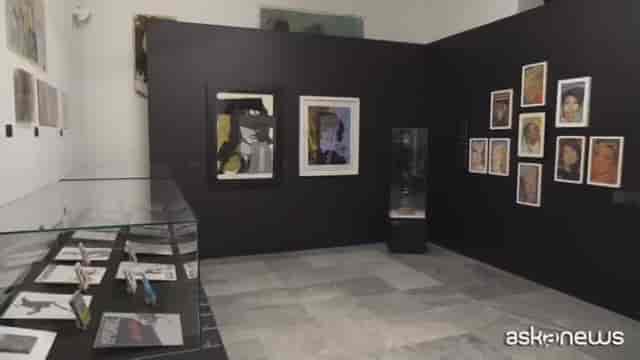 Warhol and Banksy exhibit gallery with black walls for art exhibition and event breakout space.