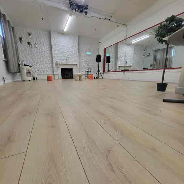 Sovereign Studios blank-canvas space with wood floors for intimate workshops and wellness events.