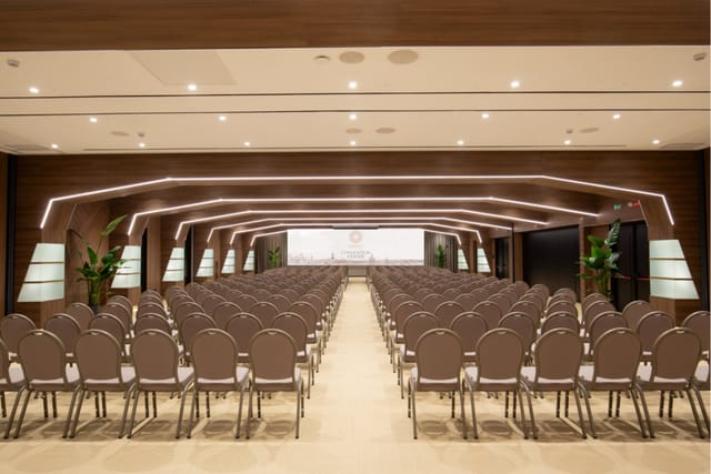 Modern ballroom with theater-style seating for corporate summits and keynote presentations.