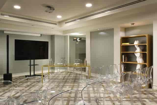 Modern sales meeting breakout space with ghost chairs and AV setup for professional presentations.
