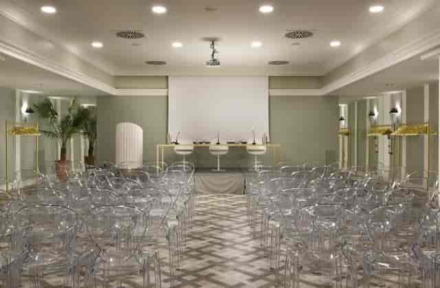 Sala Cassiopea theatre setup with ghost chairs for high-end panel discussion event space.
