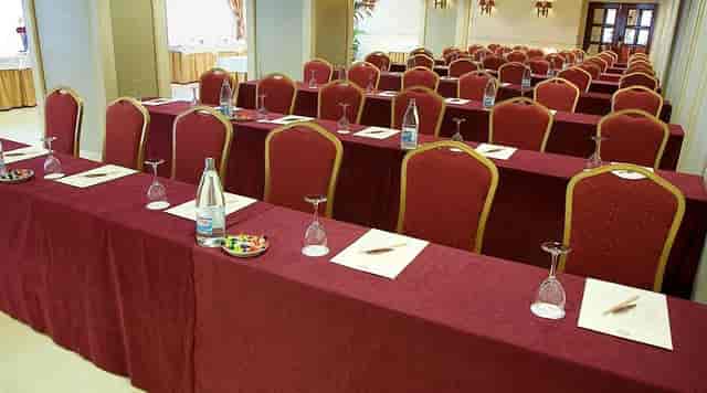 Classroom-style corporate meeting room at The Palace Hotel, featuring burgundy linens.
