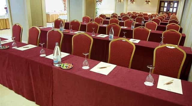 Classroom-style corporate meeting room at The Palace Hotel, featuring burgundy linens.