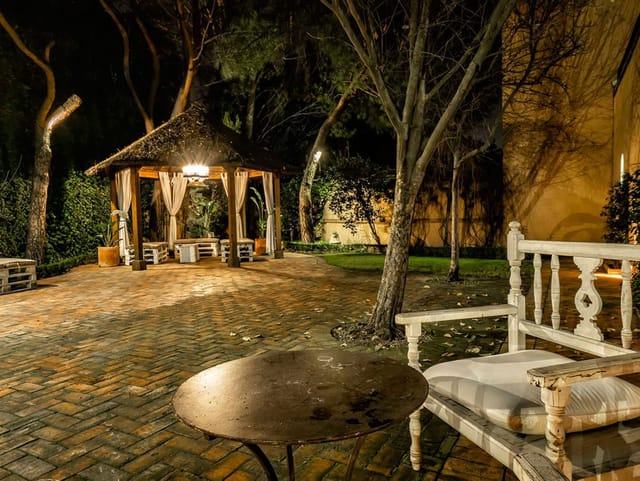 Rustic outdoor breakout session at Finca La Alquería with atmospheric lighting and pallet seating.
