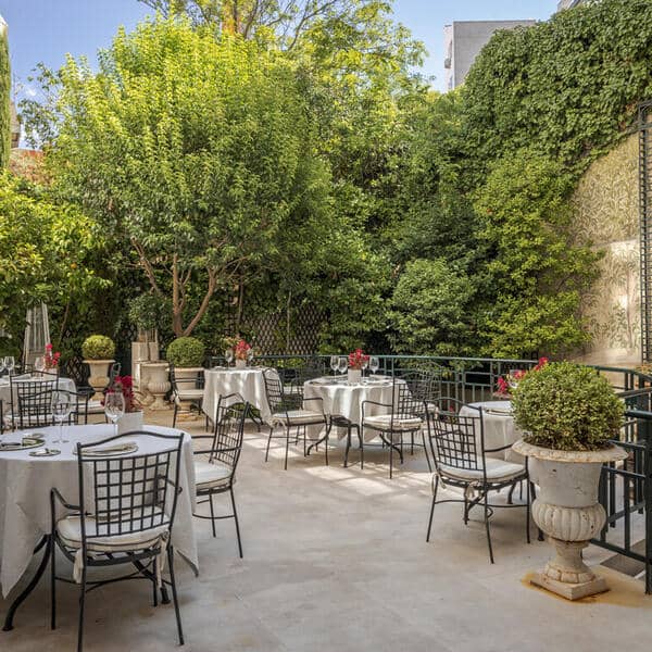 Garden Terrace at Relais & Châteaux Orfila with white tables for corporate dinners or brunch events.
