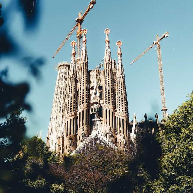Sagrada Familia architecture with construction cranes, iconic travel landmark and event venue.