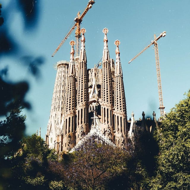 Sagrada Familia architecture with construction cranes, iconic travel landmark and event venue.