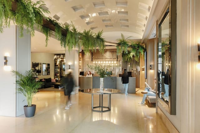 Biophilic hotel lobby event registration area with upscale lounge seating.