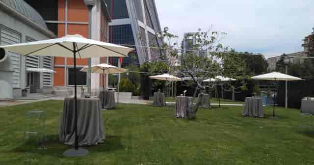 Cocktail reception at Fundación Canal gardens with umbrellas for outdoor event planning.