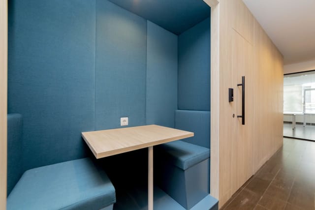 Modern huddle booth with acoustic panels for quiet office meetings and breakout sessions.