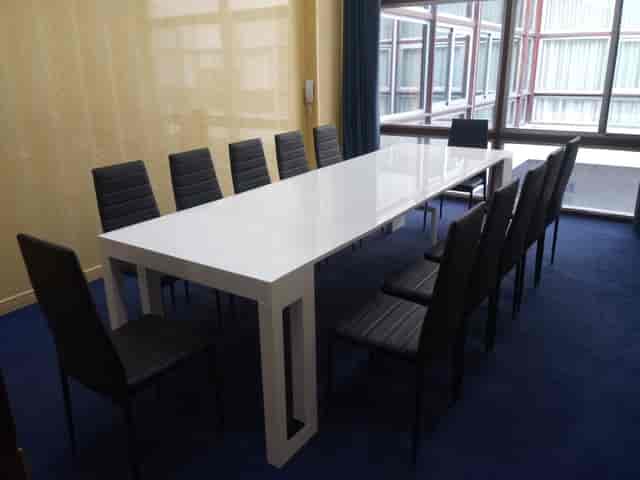 Modern boardroom at Room Eleven with white table and dark chairs for business meetings and briefings.