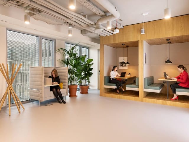 Modern hybrid meeting rooms with acoustic booths for professional coworking and breakout sessions.