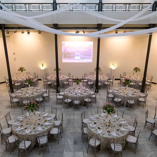Sala Polivalente industrial gala venue with floral centerpieces for corporate events or weddings.