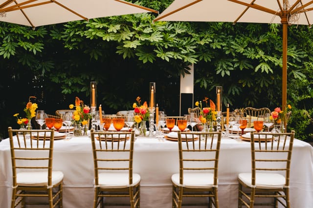 Alfresco dinner at The Garden Restaurant, Madrid: luxury event setup with candles and gold chairs.