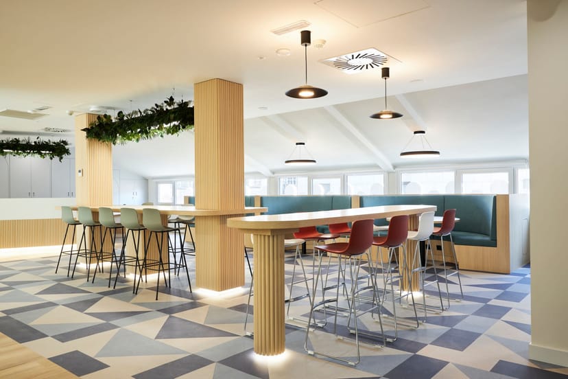 Modern coworking meeting room with communal tables for workshops and networking events.