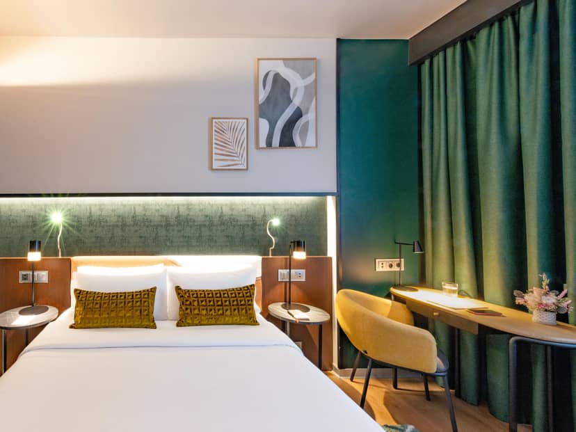 Modern Crowne Plaza Madrid hotel room with ergonomic workspace for business conferences.