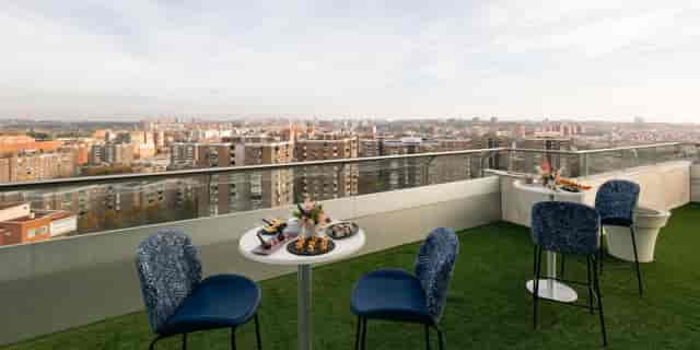 Rooftop terrace networking event at Crowne Plaza Madrid with skyline views and bistro seating.