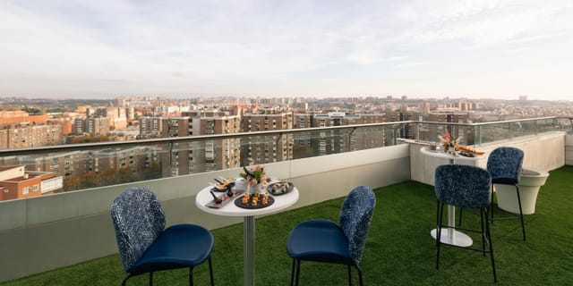 Rooftop terrace networking event at Crowne Plaza Madrid with skyline views and bistro seating.