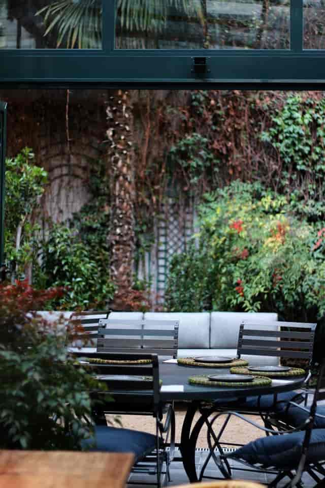 Intimate networking cafe space with lush natural decor for business meetings and coffee breaks.
