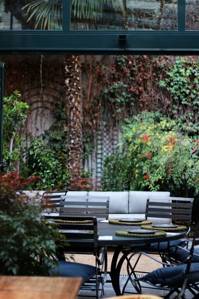 Intimate networking cafe space with lush natural decor for business meetings and coffee breaks.