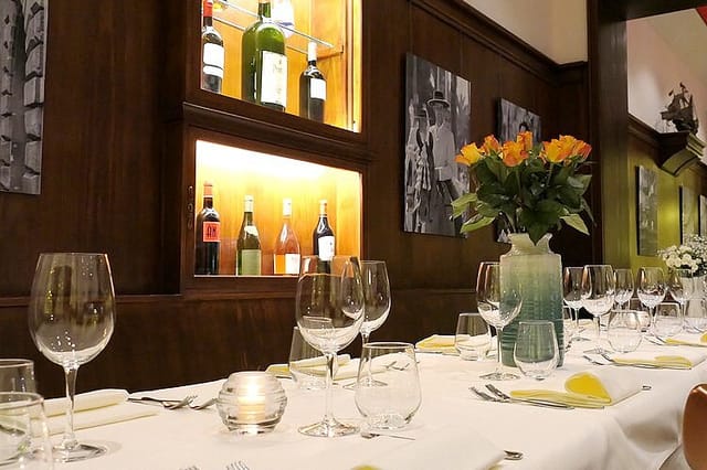 Private dining room with wood panels and wine display for corporate events and executive dinners.
