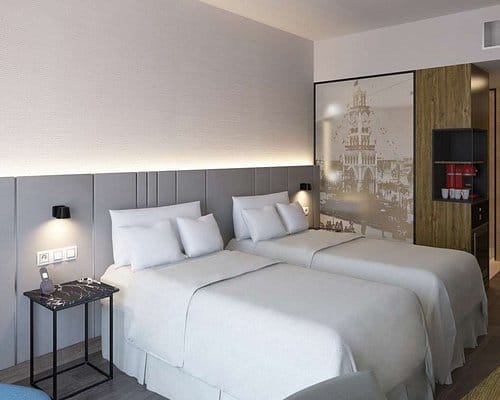 Modern hotel twin room at NH Iquique Pacífico for conference event accommodation.