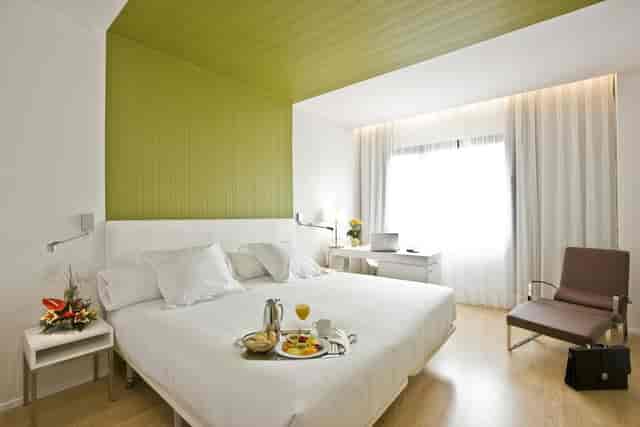 Modern hotel guest room with workspace for bleisure corporate housing and VIP speaker stays.