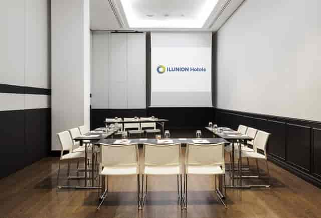 Modern U-shape boardroom at ILUNION Suites Madrid for collaborative meetings and workshops.