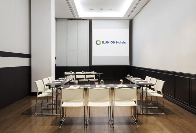 Modern U-shape boardroom at ILUNION Suites Madrid for collaborative meetings and workshops.