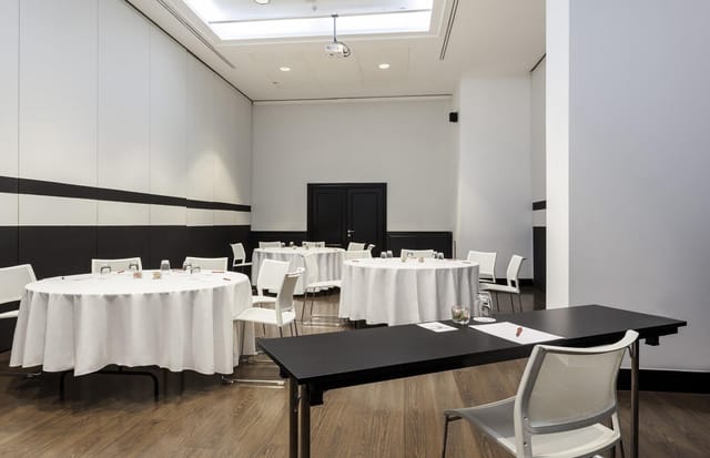 Modern breakout meeting room at ILUNION Suites Madrid for corporate events and classroom training.