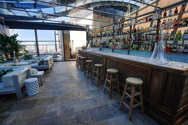 Rooftop bar with retractable roof at Hotel Urban, ideal for corporate events and networking.