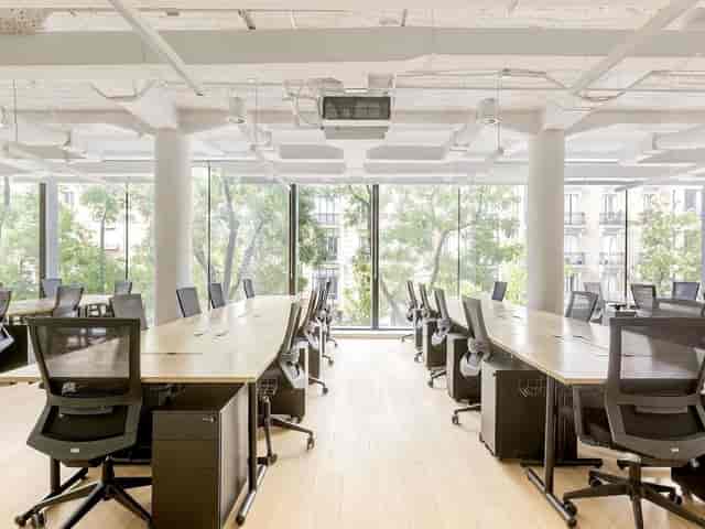 Modern private coworking boardroom with linear desks for focused professional meetings.