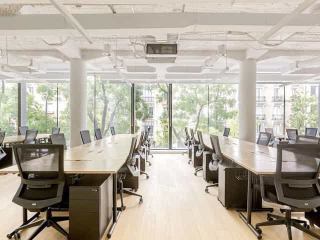 Modern private coworking boardroom with linear desks for focused professional meetings.