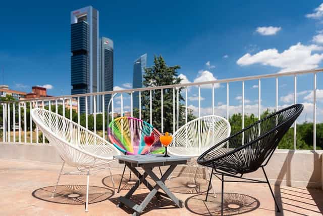 Networking cocktail reception at Madrid Chamartín hotel with urban skyline view.