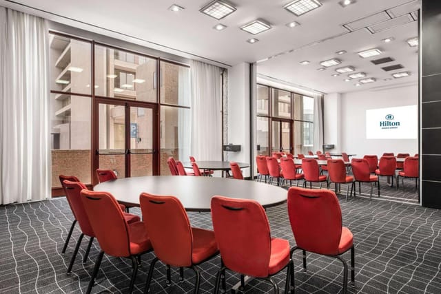 Hilton Madrid Airport meeting space with floor-to-ceiling windows for conferences and workshops.