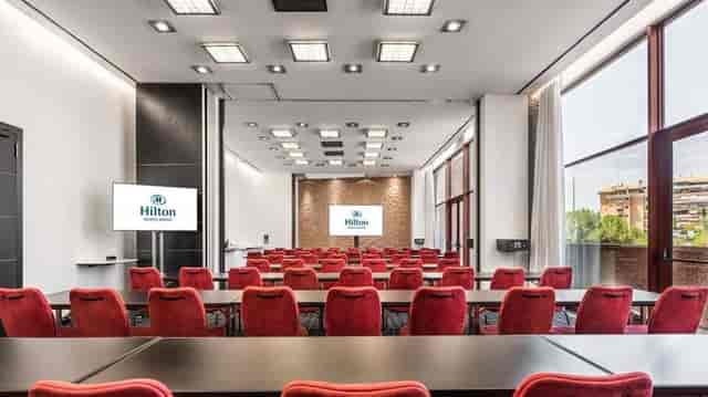 Classroom-style banquet hall with dual screens at Hilton Madrid Airport for corporate training.