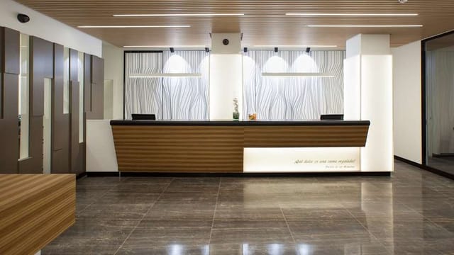 Modern reception desk at NH Madrid Chamberí business center for corporate events and conferences.
