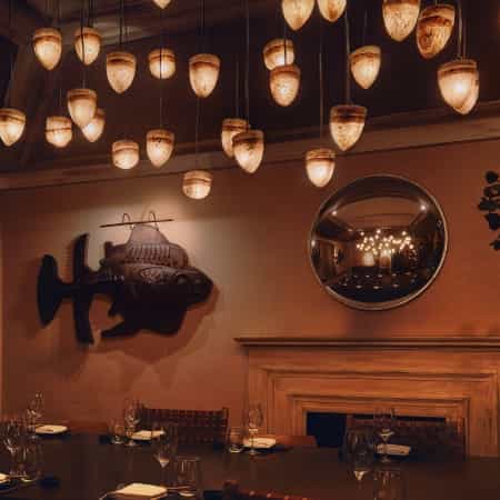 Private dining room in Velázquez featuring cascading pendant lighting for upscale events.