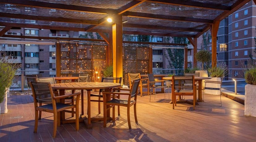 Rooftop terrace with string lights and modular furniture for networking events and corporate meetings.