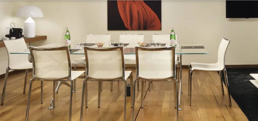 Minimalist boardroom at Palazzo Montemartini with glass table for executive meetings and events.